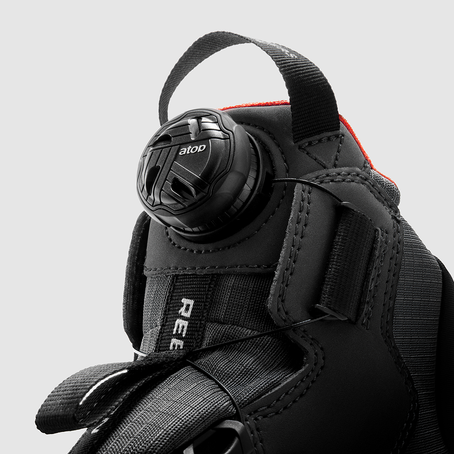 Close-up of a black diving mask with visible branding on a gray background