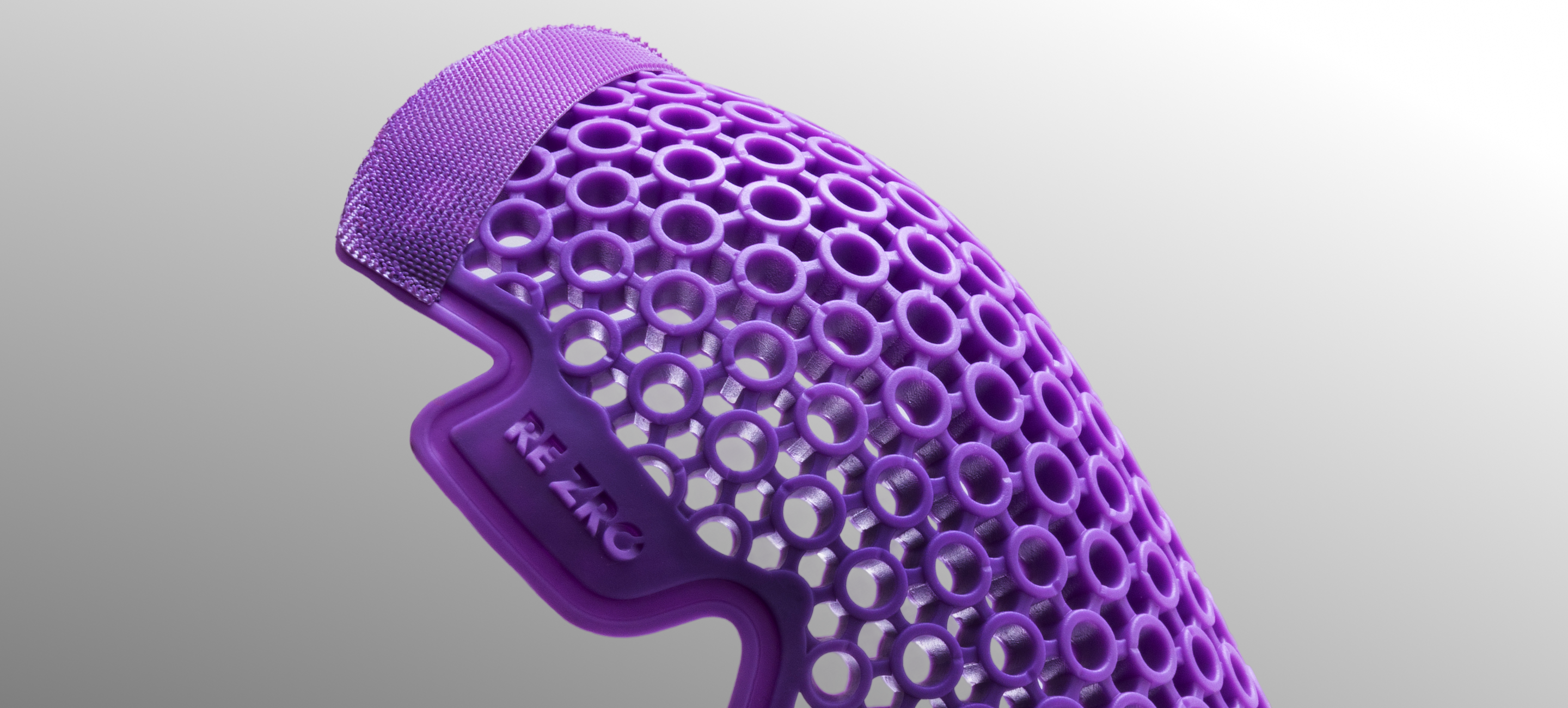 Purple honeycomb-patterned object with 'RE-ZRO' branding on a gray background